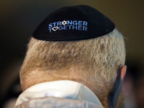 A man takes part in a vigil outside the Tree of Life Synagogue in the Squirrel Hill neighborhood of Pittsburgh to honor the victims of the Saturday attack on a synagogue in California, Saturday April 27, 2019. It is six months to the day that a gunman shot and killed 11 people while they worshipped at the Tree of Life Synagogue on Oct. 27, 2018.