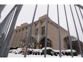 FILE--This file photo from Feb. 11, 2019 shows a temporary barrier around the Tree of Life Synagogue in Pittsburgh where 11 people were killed and seven others injured during an attack on in October of 2018. The synagogue is inviting young people worldwide to submit artwork in an art project called "#HeartsTogether: The Art of Rebuilding." to cover adjacent fencing that surrounds the still-shuttered building. They are looking for "original, uplifting images and graphics" to be printed on windscreens that will cover the temporary perimeter fencing.