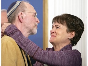 Daniel Leger, left, and Andrea Wedner, both survivors of the Tree of Life synagogue shooting, embrace after Pittsburgh Mayor Bill Peduto signed three gun-control bills into law, Tuesday, April 9, 2019, at the City-County Building in downtown Pittsburgh.