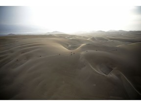 FILE - In this Jan. 16, 2019 photo, competitors ride their motorbikes across the dunes during stage nine of the Dakar Rally in Pisco, Peru. Dakar organizers say next year's cross-country race will be held in "the deep and mysterious deserts of the Middle East, in Saudi Arabia."