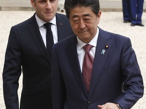 French President Emmanuel Macron, left, welcomes Japan's Prime Minister Shinzo Abe before their talks at the Elysee Palace, Tuesday, April 23, 2019 in Paris.