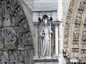 A statue is pictured just outside Notre Dame cathedral Wednesday, April 17, 2019 in Paris. Notre Dame Cathedral would have been completely burned to the ground in a "chain reaction collapse" had firefighters not moved rapidly in deploying their equipment to battle the blaze racing through the landmark monument, a Paris official said Wednesday.