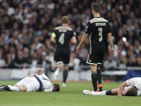 Tottenham's Jan Vertonghen, right, and Tottenham's Toby Alderweireld, left, lie on the pitch after colliding during the Champions League semifinal first leg soccer match between Tottenham Hotspur and Ajax at the Tottenham Hotspur stadium in London, Tuesday, April 30, 2019.