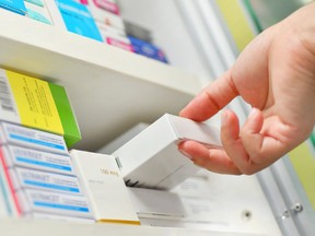 Closeup pharmacist hand holding medicine box in pharmacy drugstore.