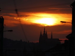 FILE - In this Wednesday, April 10, 2019 file photo, the sun sets behind the St. Vitus cathedral in Prague, Czech Republic. On Tuesday, April 23, 2019, Czech Parliament's lower house has overridden a veto of the upper house to approve a proposal drafted by Communist lawmakers to tax the compensation that the country's churches receive for property seized by the former Communist regime.