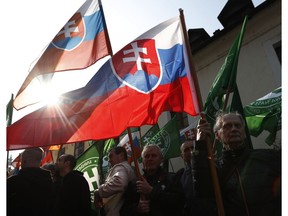 Supporters of the far right Kotleba - People's Party Our Slovakia, wave their party and Slovakia national flags outside the Supreme Court in Bratislava, Slovakia, Tuesday, April 9, 2019. The Supreme Court is considering to ban Marian Kotleba's far-right party.