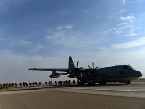 US Marines board a C-130J Super Hercules transport aircraft headed to Kandahar as British and US forces withdraw from the Camp Bastion-Leatherneck complex at Lashkar Gah in Helmand province on October 27, 2014. British forces October 26 handed over formal control of their last base in Afghanistan to Afghan forces, ending combat operations in the country after 13 years which cost hundreds of lives. The Union Jack was lowered at Camp Bastion in the southern province of Helmand, while the Stars and Stripes came down at the adjacent Camp Leatherneck -- the last US Marine base in the country.