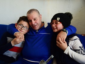 A handout picture released by the official Syrian Arab News Agency (SANA) on April 28, 2019 shows Zidan Tawil, who was released by Israel in a "goodwill gesture", hugging his children upon arrival to Syria. - Israel released today two Syrian prisoners after the remains of one of its soldiers missing since 1982 were returned earlier this month.