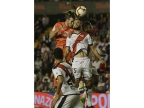 Real Madrid's Gareth Bale, left and Rayo Vallecano's Mario Suarez jump for the ball during a Spanish La Liga soccer match between Rayo Vallecano and Real Madrid at the Vallecas stadium in Madrid, Spain, Sunday, April 28, 2019.
