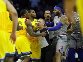 Officials separate Milwaukee Bucks' Eric Bledsoe, left, and Philadelphia 76ers' Mike Scott after a foul during the first half of an NBA basketball game, Thursday, April 4, 2019, in Philadelphia.