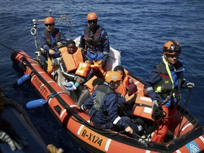This April 3, 2019 photo shows migrants on a rubber dinghy rescued by the Sea-Eye rescue ship in the waters off Libya. The humanitarian ship Sea-Eye with 64 rescued migrants aboard was stuck at sea on Thursday as Italy and Malta refuse it safe harbor as their refusal set the stage for another Mediterranean standoff that can only be resolved if European governments agree to accept the asylum-seekers.