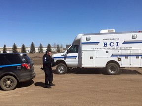 In this Wednesday, April 3, 2019 photo, state and local police search a field in Manton, N.D., about half a mile from a business where an owner and three employees were found dead. Authorities on Thursday said they were looking for "potential evidence" related to the deaths discovered Monday at RJR Maintenance and Management in Mandan, a city just outside Bismarck. Police haven't yet identified a suspect.