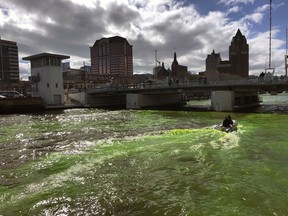 A boat helps mix green dye poured into the Milwaukee River in Milwaukee, Wisc., Friday, April 12, 2019. City and team officials turned the river green to celebrate the Milwaukee Bucks and the team's color as they head into the NBA playoffs seeded number one in the Eastern Conference.