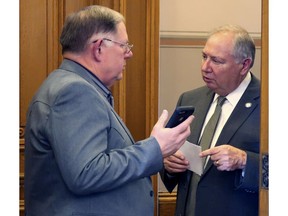 In this Friday, April 5, 2019 photo, Kansas House Majority Leader Dan Hawkins, left, confers with Senate Majority Leader Jim Denning, R-Overland Park, at the back of the House chamber in Topeka, Kansas. GOP leaders have announced plans to have a committee study Medicaid expansion this summer and fall to head off a push for passing expansion this year.