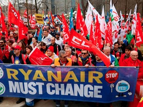 UBT-FGTB Transport trade union members hold a banner reading "Ryanair must change" during protests against the "social dumping" in a "Fair Transport" in Brussels on March 27, 2019.