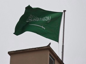 A bird sits by a Saudi Arabia's flag on the roof top of Saudi Arabia's consulate in Istanbul, Sunday, Oct. 14, 2018.