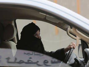 FILE - In this March 29, 2014 file photo, Aziza al-Yousef drives a car on a highway in Riyadh, Saudi Arabia, as part of a campaign to defy Saudi Arabia's then ban on women driving. Nearly a dozen Saudi women's rights activists,  most of them imprisoned, have attended their third court session Wednesday, April 3, 2019, and were told their trials will continue for at least two more weeks. Meanwhile, three women who were granted temporary release last week, among them al-Yousef and Eman al-Najfan, were told their next court date would take place after the Muslim holy month of Ramadan, which coincides with early June.