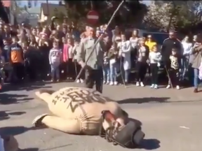 A screenshot of the video showing people beating and burning a Jewish effigy in Poland as part of an Easter ritual