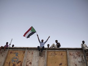 A protester waves a Sudanese national flag during a sit-in at Armed Forces Square in Khartoum, Sudan, Saturday, April 27, 2019. The Umma party of former Prime Minister Sadiq al-Mahdi, a leading opposition figure, said the protesters will not leave until there is a full transfer of power to civilians.