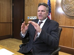 In this March 8, 2019 photo, Alaska Gov. Mike Dunleavy talks to reporters during a news conference in Juneau, Alaska. Dunleavy is proposing sweeping budget cuts as part of a plan that would provide Alaskans a full payout from the state's oil-wealth fund, but many state residents believe the proposed cuts to government services and programs would go too far.