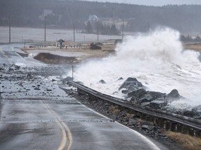 Waves pound the shore on a closed section of Highway 207 in Lawrencetown, N.S. on Friday, Jan. 5, 2018.