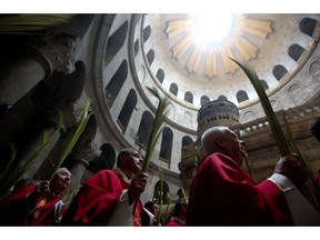 Catholic priests carry palm fronds at the Church of the Holy Sepulchre, traditionally believed by many Christians to be the site of the crucifixion and burial of Jesus Christ, in Jerusalem's old city, Sunday, April 14, 2019. Palm Sunday marks for Christians, Jesus Christ's entrance into Jerusalem, when his followers laid palm branches in his path, prior to his crucifixion.