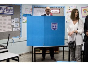 Blue and White party leader Benny Gantz, right, casts his vote with his wife Revital Gantz left, and former Israeli Chief of Staff Benny Gantz during Israel's parliamentary elections in Rosh Haayin, Israel, Tuesday, April 9, 2019.