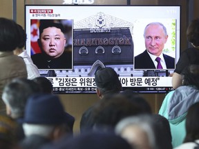 People watch a TV screen showing images of North Korean leader Kim Jong Un, left, and Russian President Vladimir Putin, right, during a news program at the Seoul Railway Station in Seoul, South Korea, Tuesday, April 23, 2019. North Korea confirmed Tuesday that Kim will soon visit Russia to meet with Putin in a summit that comes at a crucial moment for tenuous diplomacy meant to rid the North of its nuclear arsenal. The Korean letters on the screen read:: "Kim Jong Un plans to visit Russia ."