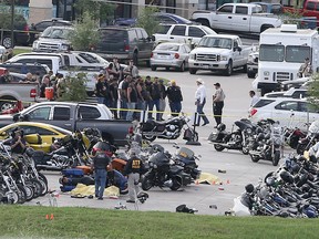 Authorities investigate a shooting in the parking lot of the Twin Peaks restaurant Sunday, May 17, 2015, in Waco, Texas. Authorities say that the shootout victims were members of rival biker gangs that had gathered for a meeting.