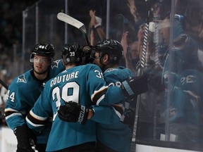 San Jose Sharks' Marc-Edouard Vlasic (44) and Logan Couture (39) celebrate goal by Gustav Nyquist (14), center, against the Colorado Avalanche in the first period of Game 1 of an NHL hockey second-round playoff series at the SAP Center in San Jose, Calif., on Friday, April 26, 2019.