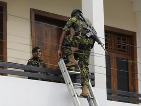 In this Sunday, April 21, 2019, photo, a Sri Lankan police commando enters a house suspected to be a hideout of militants following a shoot out in Colombo, Sri Lanka. Sri Lankan authorities blame seven suicide bombers of a domestic militant group for coordinated Easter bombings that ripped through Sri Lankan churches and luxury hotels which killed and injured hundreds of people. It was Sri Lanka's deadliest violence since a devastating civil war in the South Asian island nation ended a decade ago.