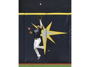 Tampa Bay Rays center fielder Kevin Kiermaier leaps to catch a fly ball hit by Colorado Rockies' David Dahl during the first inning of a baseball game Wednesday, April 3, 2019, in St. Petersburg, Fla.