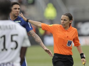 French referee Stephanie Frappart, right, in action during the French League One soccer match between Amiens and Strasbourg, at the Stade de la Licorne stadium in Amiens, France, Sunday, April 28, 2019. Stephanie Frappart is the first woman to referee a Ligue One soccer match in France.