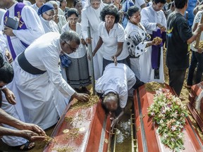 Relatives of the dead offer their prayers during funerals in Katuwapity village on April 23, 2019 in Negambo, Sri Lanka.
