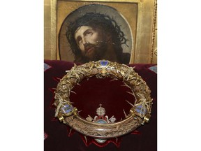 FILE - In this Friday March 21, 2014 file photo a crown of thorns which was believed to have been worn by Jesus Christ and which was bought by King Louis IX in 1239 is presented at Notre Dame Cathedral in Paris. Paris' mayor, Anne Hidalgo, said a significant collection of art and holy objects inside the church had been recovered from the fire at Notre Dame cathedral. In a tweet later, she thanked firefighters and others who formed a human chain to save artifacts. "The crown of thorns, the tunic of St. Louis and many other major artifacts are now in a safe place," she wrote.