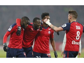 Lille players celebrate after PSG's Thomas Meunier scored an own goal during the French League One soccer match between OSC Lille and Paris-Saint-Germain at Stade Pierre Mauroy in Lille, France, Sunday, April 14, 2019.