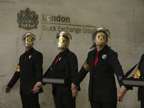 Extinction Rebellion climate protesters form a line after glueing themselves to the entrances of the London Stock Exchange in the City of London, Thursday April 25, 2019.