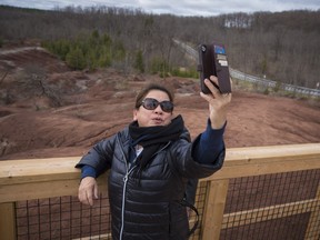 Lynne Jereza from California, takes a photo while visiting the badlands with relatives from Brampton, during a day trip to Cheltenham, Ont. on Wednesday, April 24, 2019.