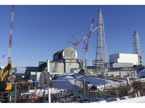FILE - In this Jan. 25, 2018, file photo, an installation of a dome-shaped rooftop cover housing key equipment is near completion at Unit 3 reactor of the Fukushima Dai-ich nuclear power plant ahead of a fuel removal from its storage pool in Okuma, Fukushima Prefecture, northeast Japan.  Japan has partially lifted an evacuation order in one of the two hometowns of the tsunami-wrecked Fukushima nuclear plant for the first time since the 2011 disaster. The action taken Wednesday, April 10, 2019, allows people to return about 40 percent of Okuma. The other hometown, Futaba, remains off-limits as are several other towns nearby.