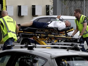 FILE - In this March 15, 2019, file photo, ambulance staff take a man from outside a mosque in central Christchurch, New Zealand. The man authorities believe carried out the Christchurch mosque attacks is due to make his second court appearance via video link on Friday, April 4, 2019, although media photographs won't be allowed and reporting on the proceedings will be limited by New Zealand law. Fifty people died in the March 15 attacks on two mosques.