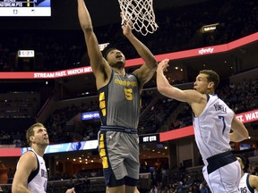 Memphis Grizzlies forward Bruno Caboclo (5) shoots between Dallas Mavericks forwards Dwight Powell (7) and Dirk Nowitzki (41) in the first half an NBA basketball game Sunday, April 7, 2019, in Memphis, Tenn.