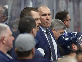 St. Louis Blues interim head coach Craig Berube, center, watches from the bench during the second period in Game 4 of an NHL first-round hockey playoff series against the Winnipeg Jets, Tuesday, April 16, 2019, in St. Louis.