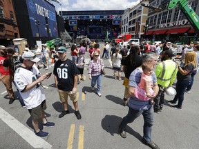 Onlookers watch the progress of the NFL stage being built ahead of the first-round NFL Draft, Wednesday, April 24, 2019, in Nashville, Tenn. The football draft is scheduled to run Thursday through Saturday.