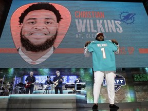 Clemson defensive tackle Christian Wilkins poses with his new jersey after the Miami Dolphins selected Wilkins in the first round at the NFL football draft, Thursday, April 25, 2019, in Nashville, Tenn.