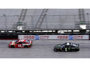 Kyle Busch (18) leads his brother Kurt Busch in the final laps of the NASCAR Cup Series auto race Sunday, April 7, 2019, at Bristol Motor Speedway in Bristol, Tenn.