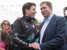 Prime Minister Justin Trudeau, left, shakes hand with Conservative Leader Andrew Scheer at the start of the Defi Pierre Lavoie, a 1000km bicycle trek, Thursday, June 14, 2018 in Saguenay Que.