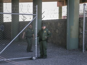 Border Patrol agents guard a gate at the entrance to what was a temporary holding facility under the Paso del Norte Port of Entry bridge in El Paso, Texas, on Sunday, March 31, 2019. Migrants, including young children and babies, seeking asylum were being kept in a U.S. Border Patrol temporary holding area under the bridge. Some migrants were held there for as many as four days and were forced to sleep outside on gravel, provided only thin Mylar blankets for warmth.