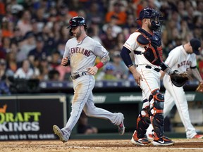Cleveland Indians' Tyler Naquin, left, scores as Houston Astros catcher Max Stassi stands in front of home plate during the seventh inning of a baseball game Saturday, April 27, 2019, in Houston.