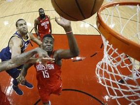 Houston Rockets' Clint Capela (15) reaches for a rebound in front of Utah Jazz center Rudy Gobert, left, during the first half of Game 2 of a first-round NBA basketball playoff series in Houston, Wednesday, April 17, 2019.