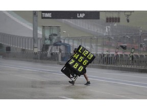 A crew member moves signage during a weather delay for practices and qualifying for the Grand Prix of the Americas motorcycle race at the Circuit Of The Americas, Saturday, April 13, 2019, in Austin, Texas.